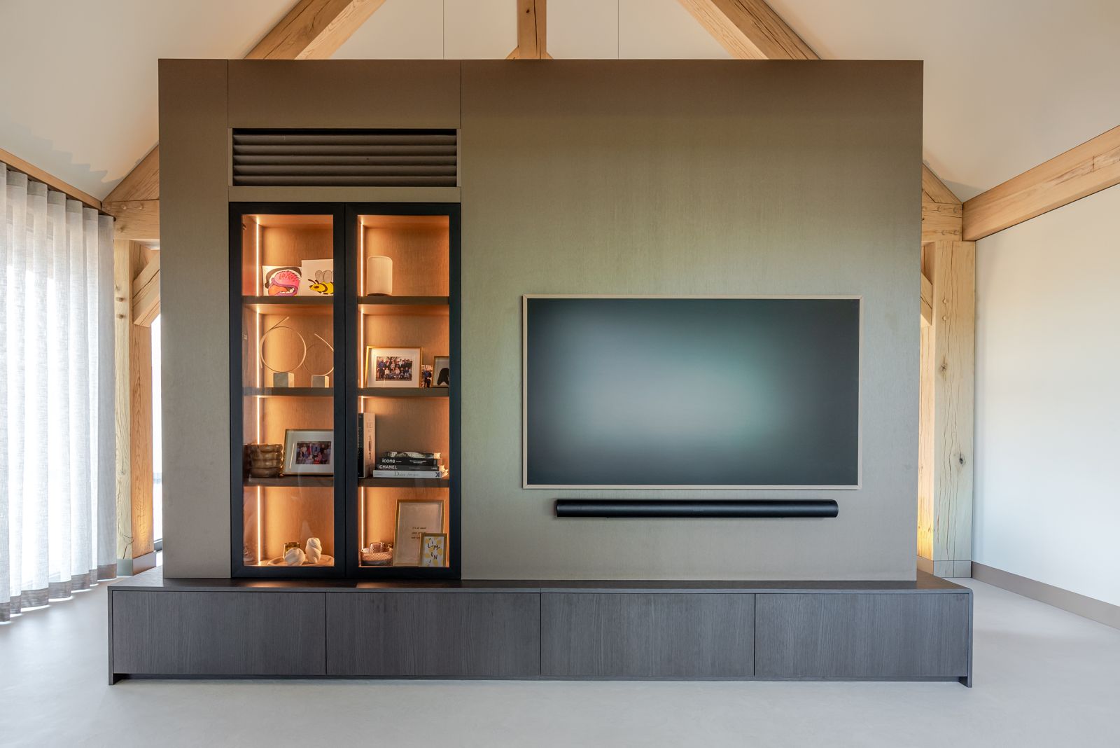 Vrijstaande televisiewand op maat met verlichte vitrinekast en donker houten dressoir