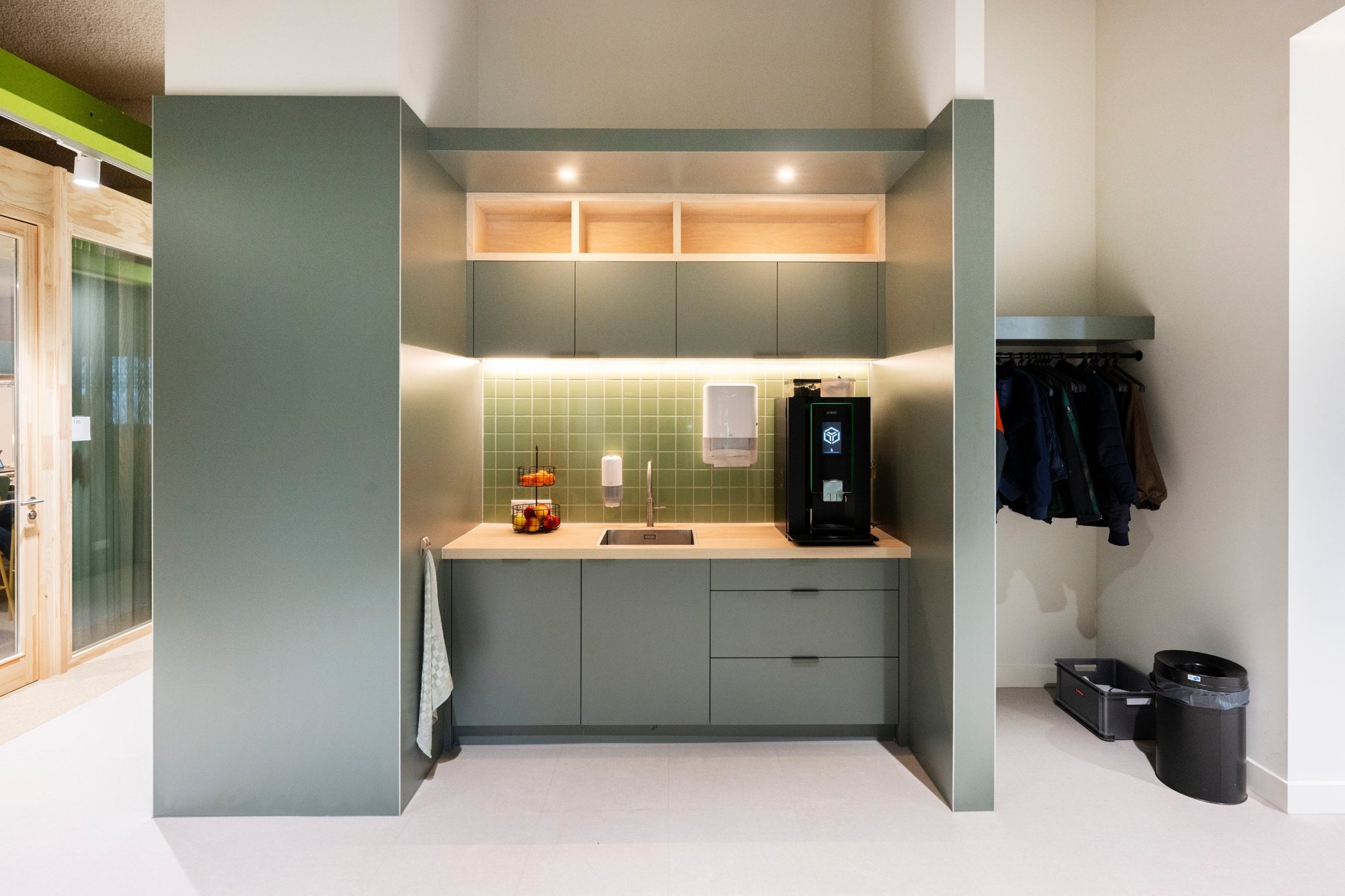 Pantry op maat in groen met open houten vakken en verlichting op kantoor